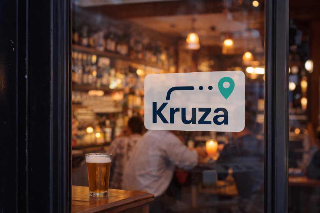 A Kruza stop sticker on a venue window, with a bar in the background